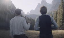 Two men dressed nicely stare off into the mountains